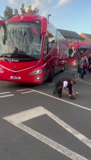 上嘴臉??利物浦大巴離開時，一名水晶宮球迷故意蹲在車前系鞋帶